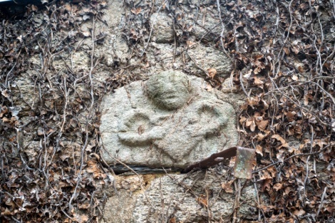 Sur la façade de cette maison, un emblème : buste d’un homme tenant dans ses bras -  peut-être un cœur - qui vient d’ailleurs